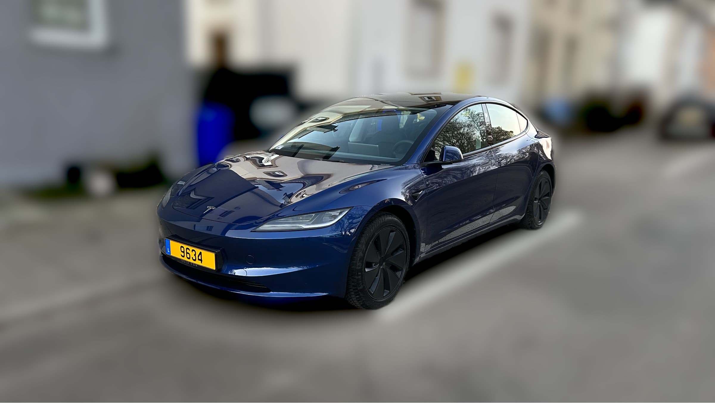 Ultra Blue Tesla Model 3 parked on a residential street in daylight